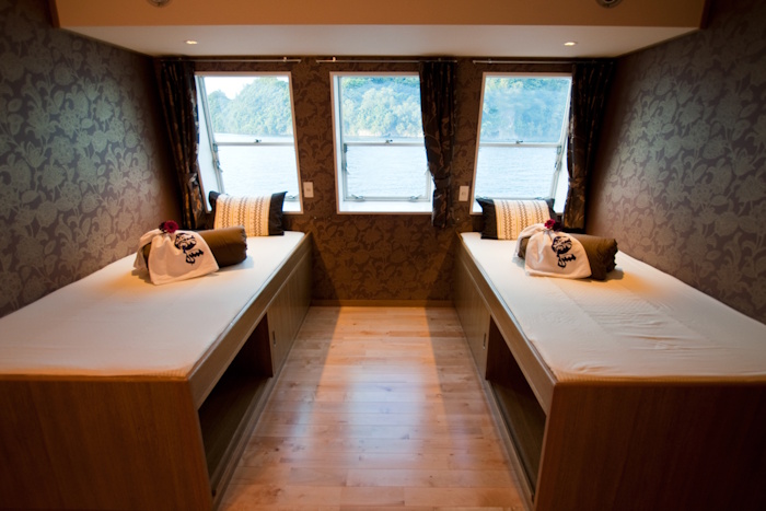 デラックスルームはツインタイプ。ベッド下にも収納スペースがあり、客室にはシャワーとトイレも設置されていて快適