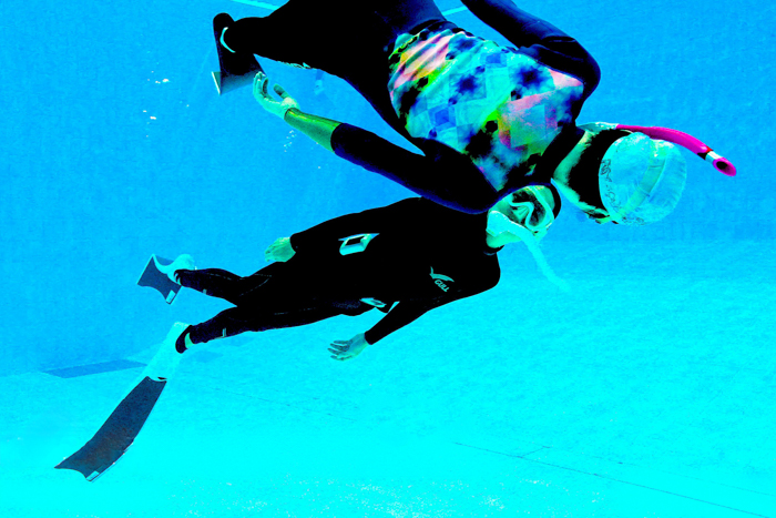 相手をイルカに見立てて、目を合わせて泳ぐ Photo by JUN HASEGAWA