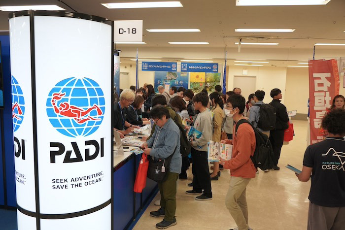 ダイビングを始めるために、講習の申し込みをする来場者の皆さん