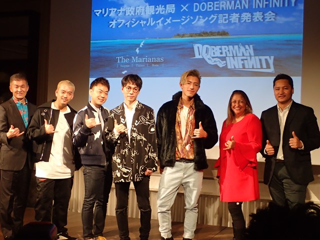 写真右からマリアナ政府観光局クリス・コンセプシオン局長、マリアナ政府観光局理事会グロリア・キャバナ会長、DOBERMAN INFINITYのKAZUKI、P-CHO、GS、KUBO-C、マリアナ政府観光局の一倉隆ゼネラルマネージャー